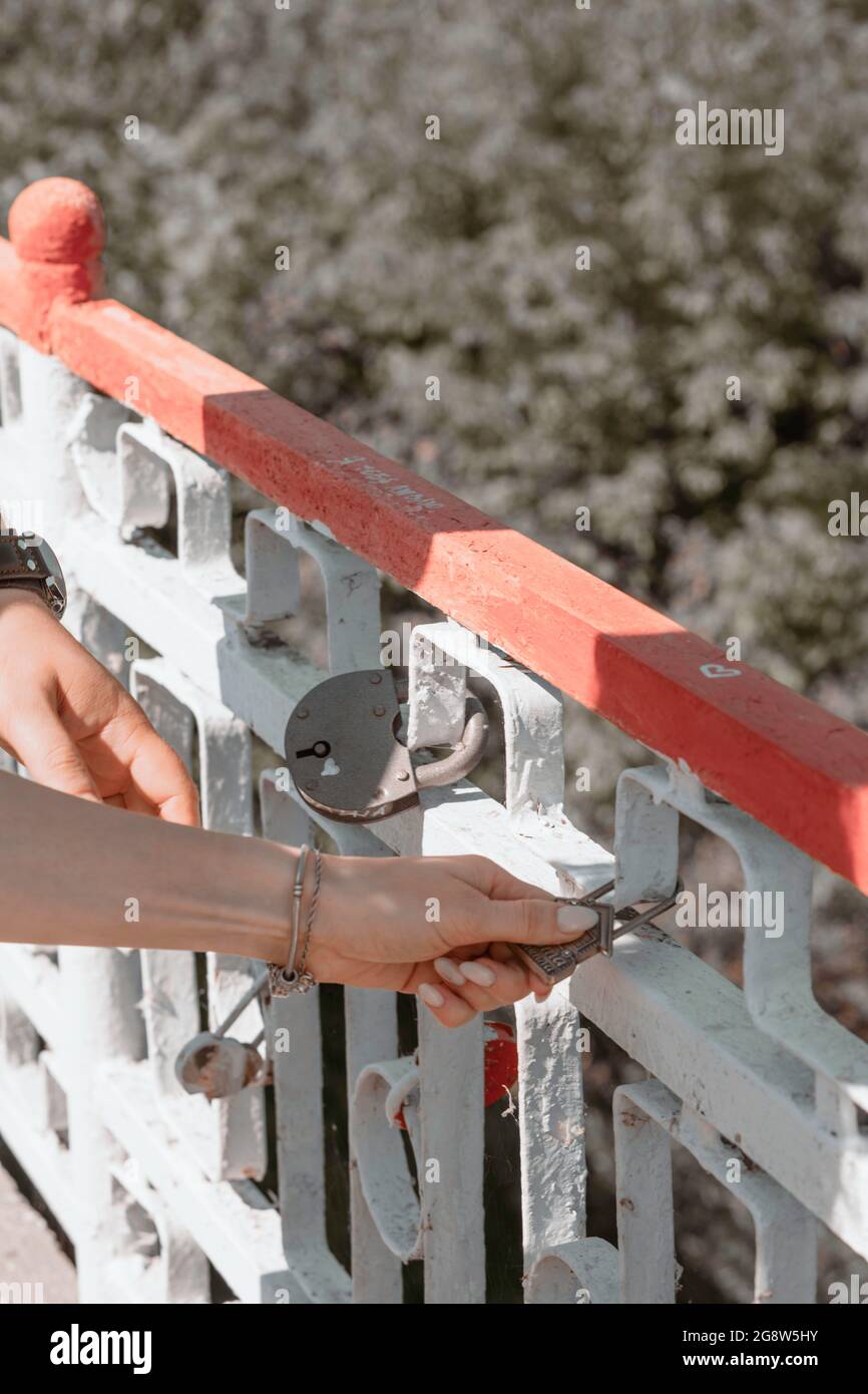 La sposa e lo sposo si bloccano. Gli sposi nuovi appendono la serratura che simboleggia l'amore eterno nel giorno del matrimonio. Tradizione nuziale. Foto Stock