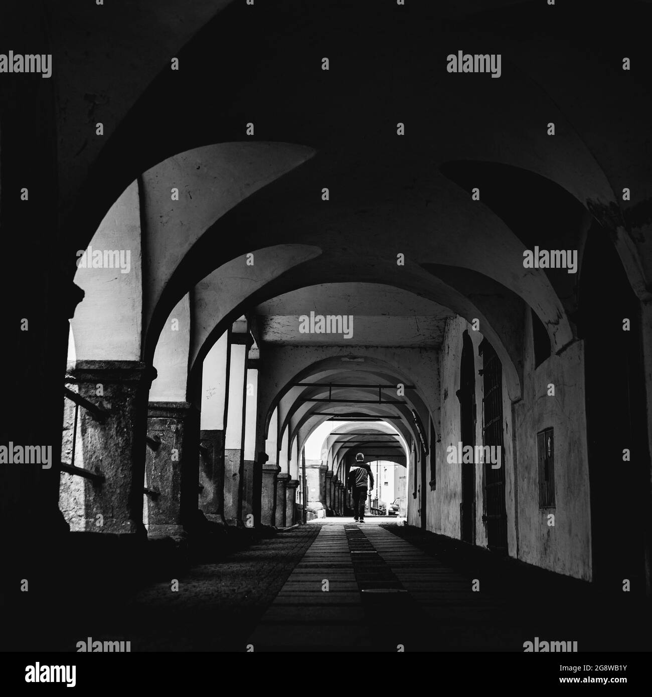 passaggio arcade in una piccola città, uomo a piedi visto da dietro Foto Stock