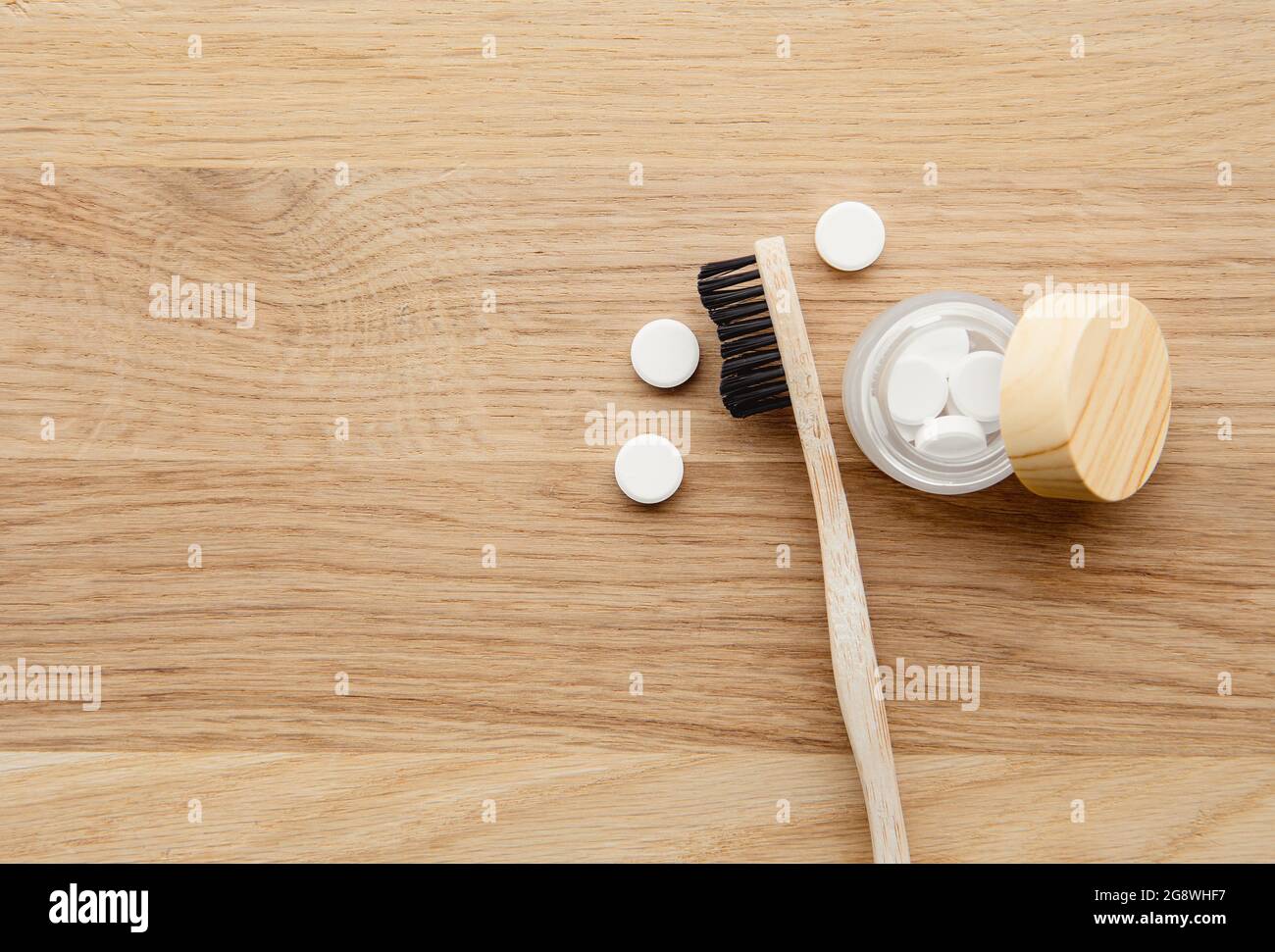 Compresse di dentifricio bianco con spazzolino di fluoruro e bambù. Cura dentale, ingredienti naturali, concetto zero rifiuti. Foto Stock