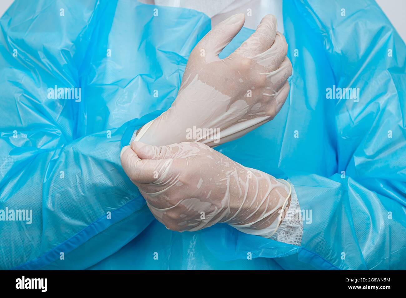 Un operatore medico che indossa guanti sudaty nel calore. Foto Stock