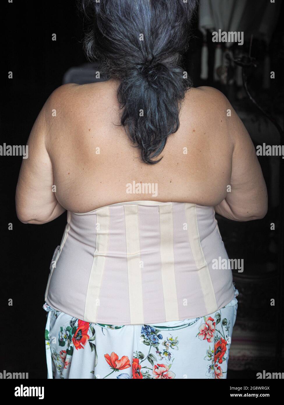 Vista posteriore di una donna anziana che indossa un corsetto toracico  semi-rigido per la cura della lumbalgia Foto stock - Alamy