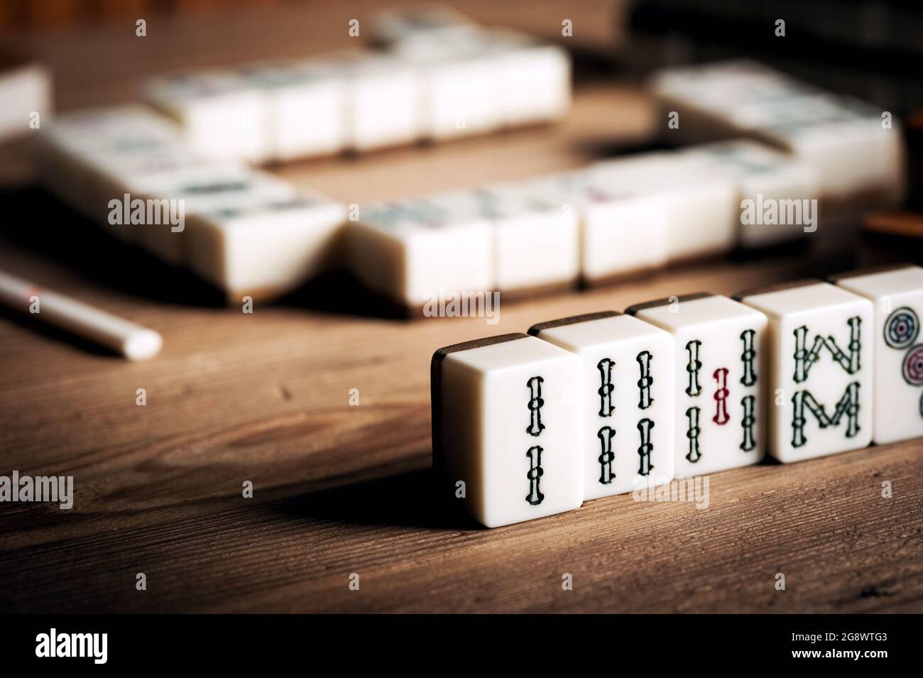 Giocare Mahjong su tavolo di legno. Mahjong è l'antico gioco da tavolo asiatico. Foto Stock