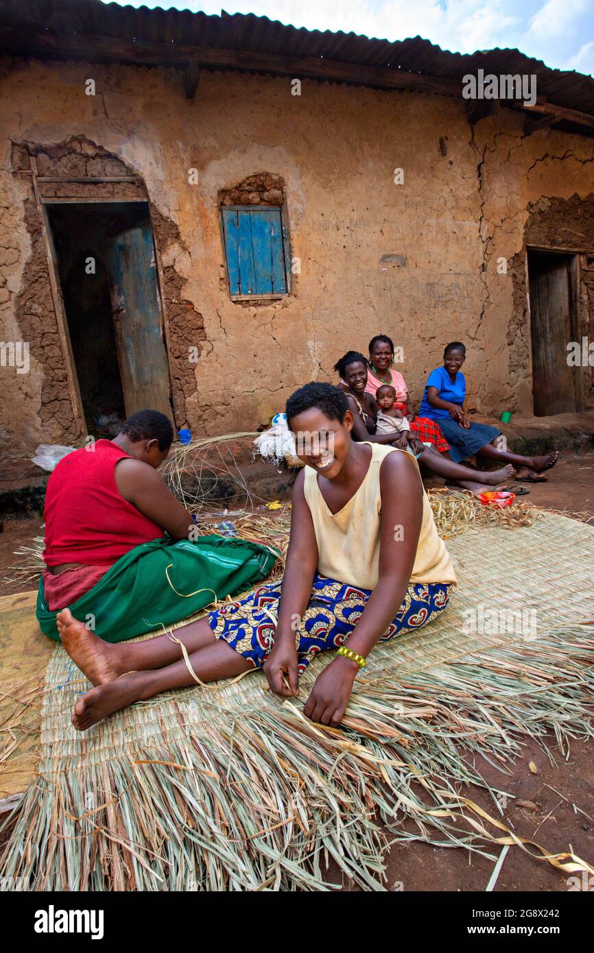 Le donne locali tessono il materasso usando le canne a Kibale, Uganda Foto Stock
