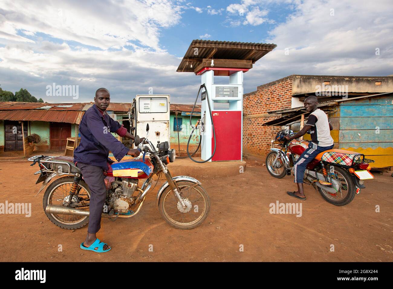 Uomini locali in moto presso il distributore di benzina di Kitwa, Uganda Foto Stock