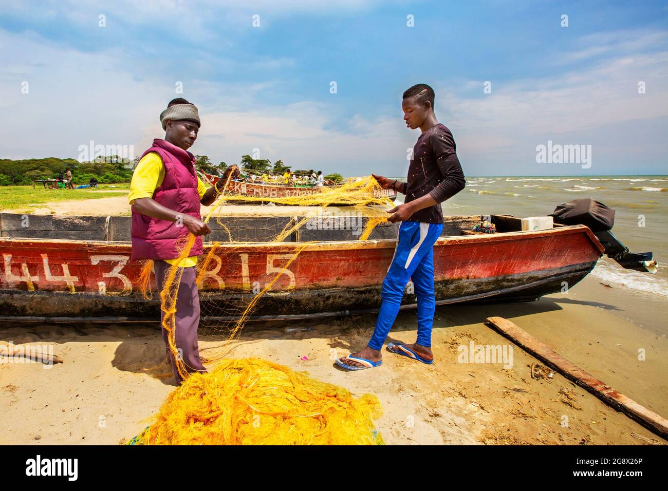 Pescatori che organizzano i loro reti da pesca nel lago George, Uganda Foto Stock