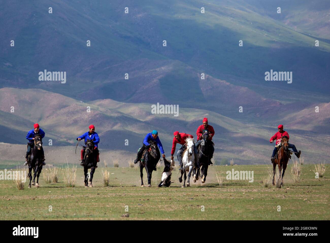 I cavalieri Nomad che giocano un tradizionale gioco di cavalli di Buzkashi conosciuto anche come Kokpar, in Issyk Kul, Kirghizistan. Foto Stock