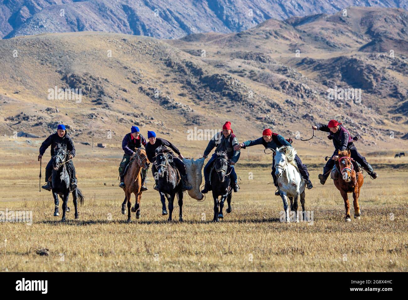 I cavalieri Nomad che giocano un tradizionale gioco di cavalli di Buzkashi conosciuto anche come Kokpar, in Issyk Kul, Kirghizistan. Foto Stock