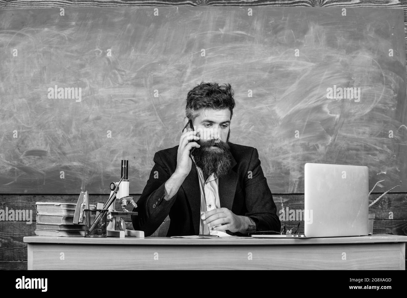 Il direttore della scuola o l'insegnante che chiama i genitori per segnalare i risultati dell'esame. L'insegnante di scuola si preoccupa della comunicazione con i genitori. Uomo con barba parlare Foto Stock