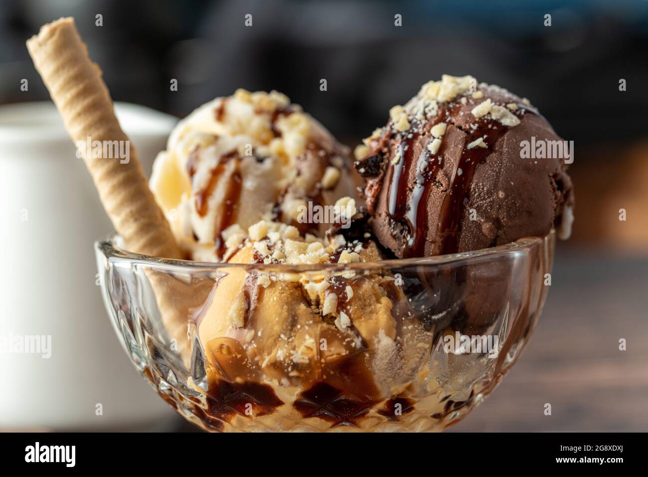 Gelato Roma al cioccolato, crema e caramello in una ciotola di vetro con salsa di nocciole e cioccolato. Foto Stock