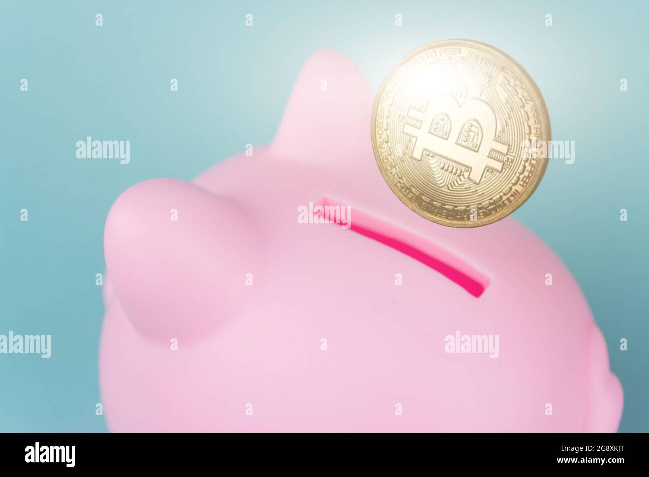 Concetto di investimento in criptovaluta. Bitcoin in una banca piggy su sfondo blu. Salvataggio del tema di archiviazione nella valuta criptata Foto Stock