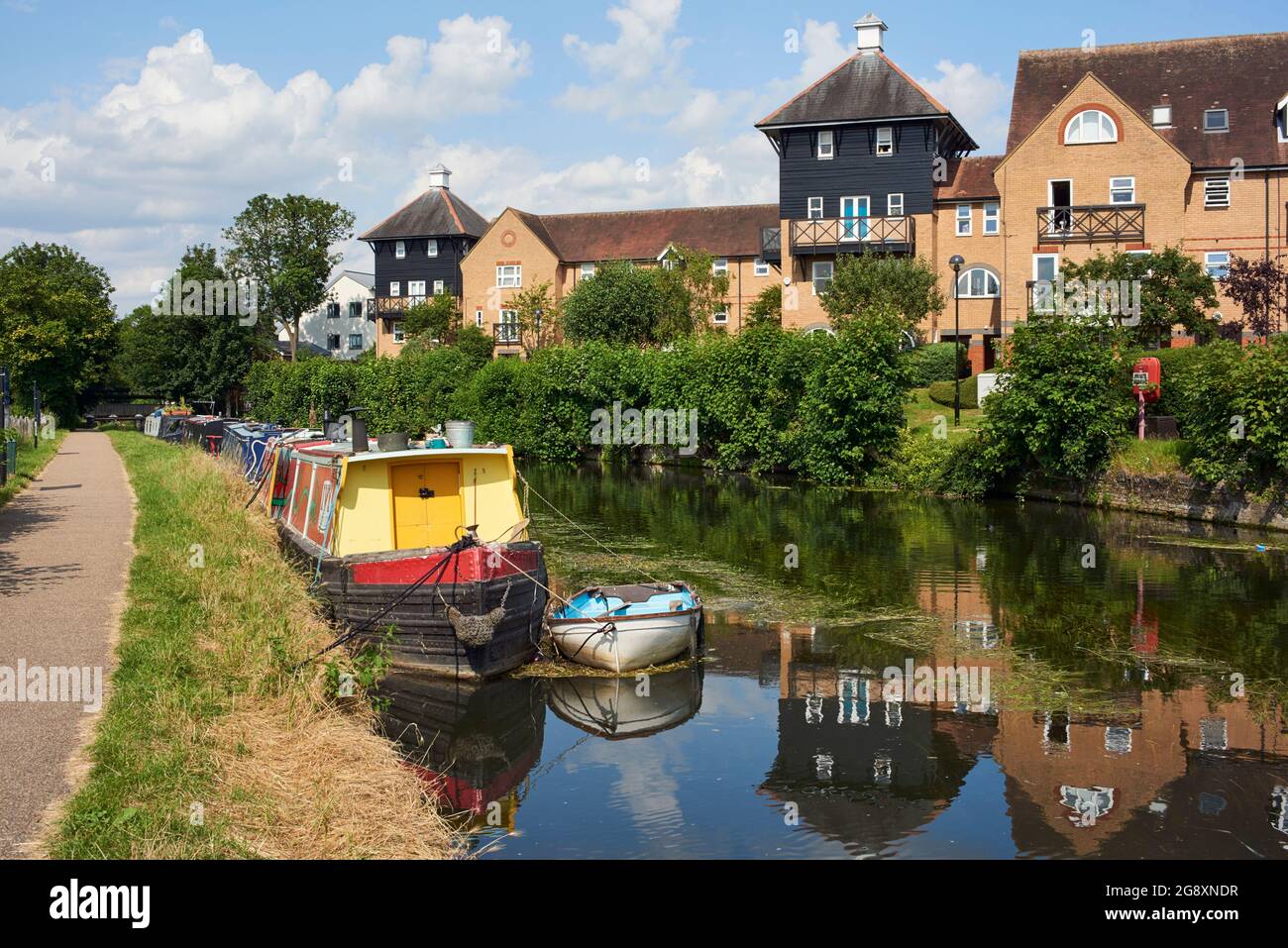 Nuove case e nettoliere lungo il fiume Lea navigazione a Hertford, Inghilterra meridionale, in estate Foto Stock