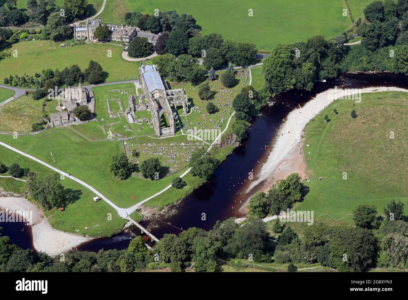 Vista aerea dell'abbazia di Bolton con i visitatori che prendono il sole e nuotano nel fiume Wharfe Foto Stock