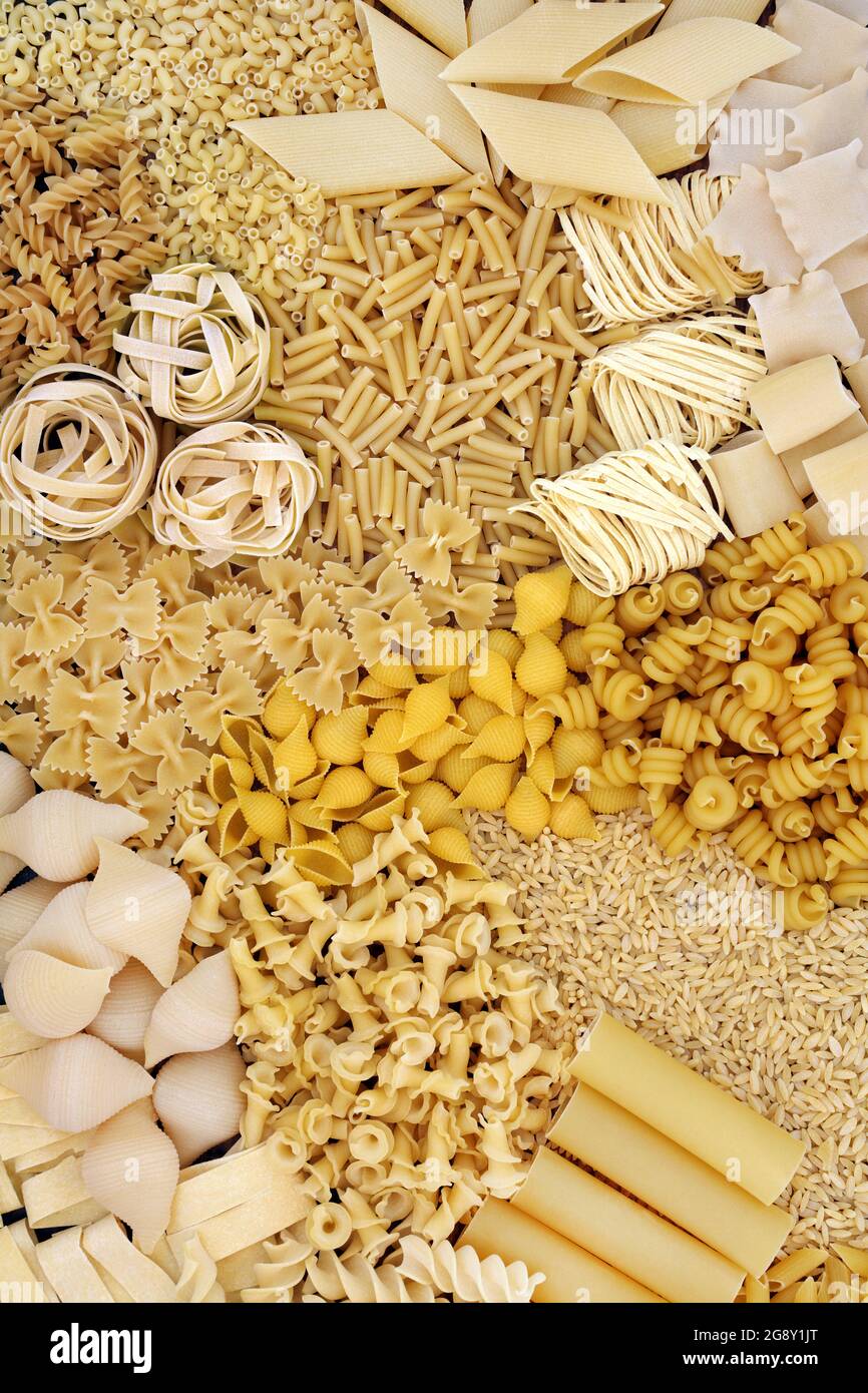 Varietà di pasta italiana secca che formano uno sfondo astratto. Disposizione piatta, vista dall'alto. Foto Stock
