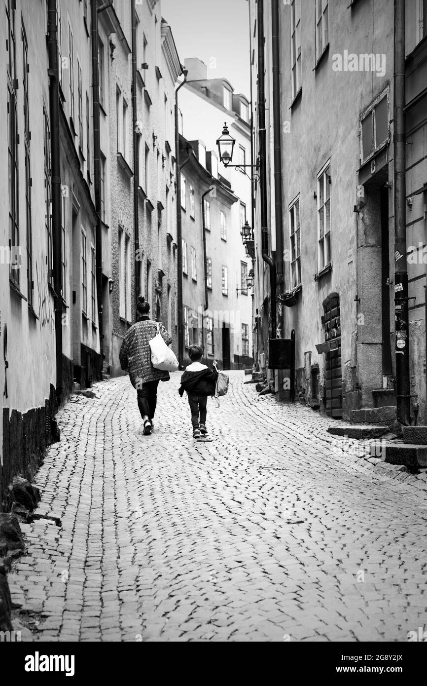 Stoccolma, Svezia - 21 maggio 2015: Strada stretta con persone a piedi nel centro storico di Stoccolma. Fotografia urbana in bianco e nero, vita cittadina Foto Stock