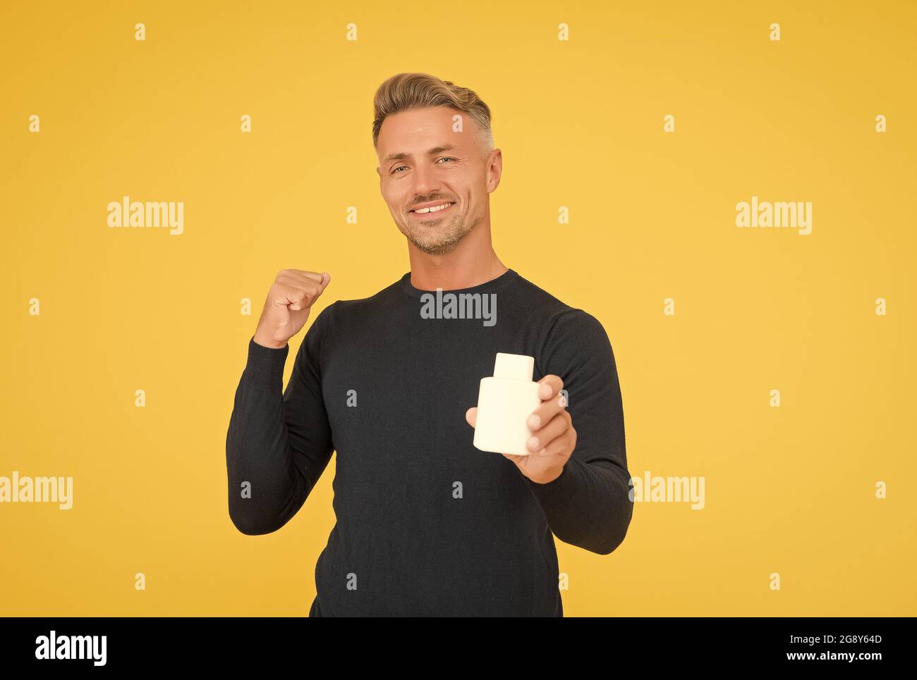 Colonia, che vi farà crescere la vostra fiducia. Uomo felice presente deodorante gesturing con sicurezza. Negozio di profumi. Cura del corpo da uomo. Balsamo post-rasatura. Dopo Foto Stock