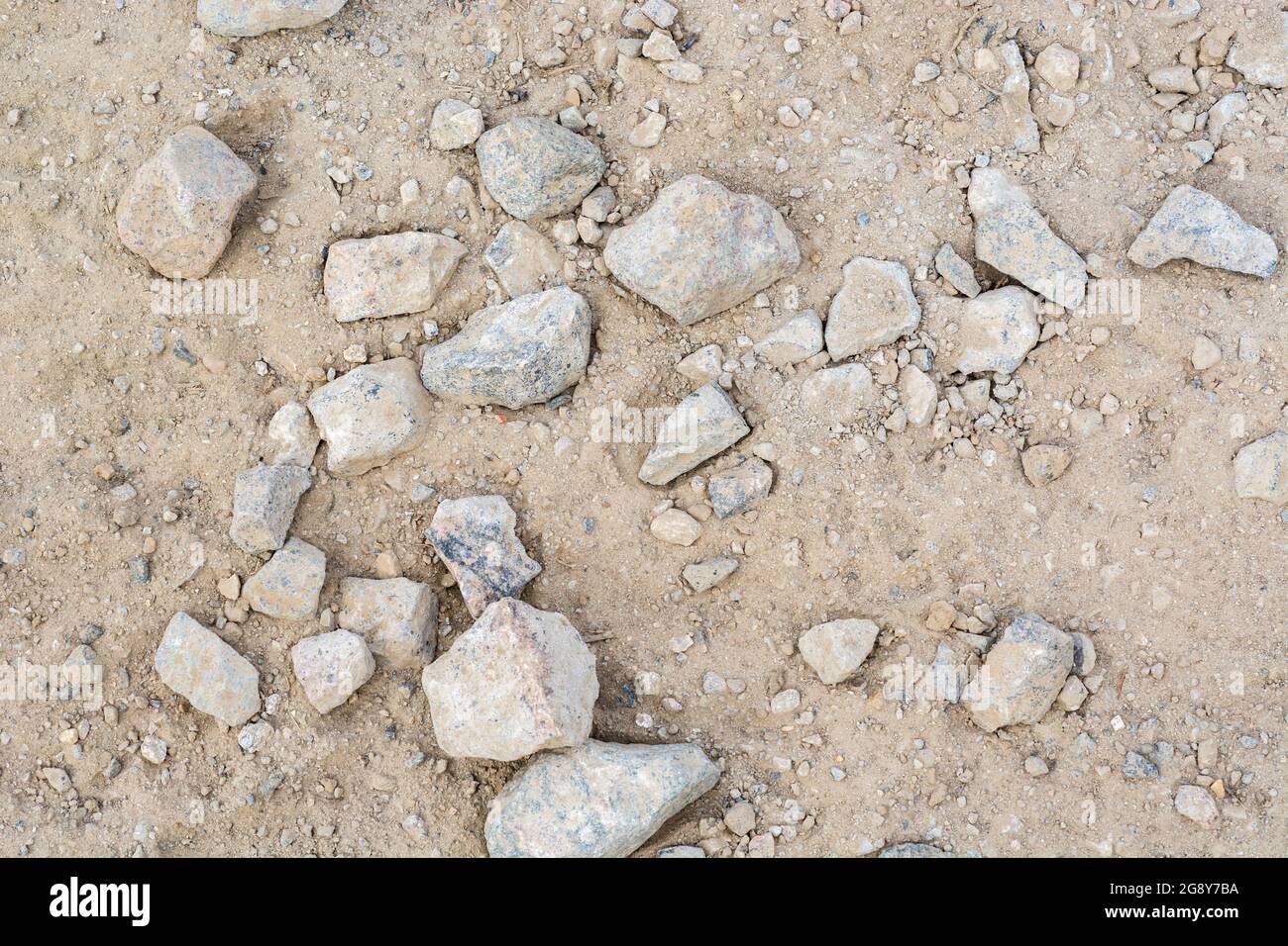Pezzi a caso di pietra dura grossolana stese su un cantiere per lavori pesanti. Pezzi più grandi di circa 2-3 pollici di larghezza. Per una strada accidentata Foto Stock