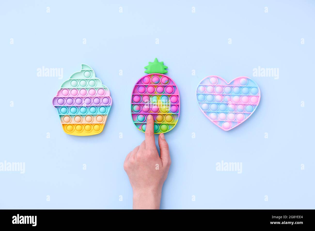 Colorati giocattoli sensoriali antistress fidget push pop su sfondo blu, vista dall'alto Foto Stock