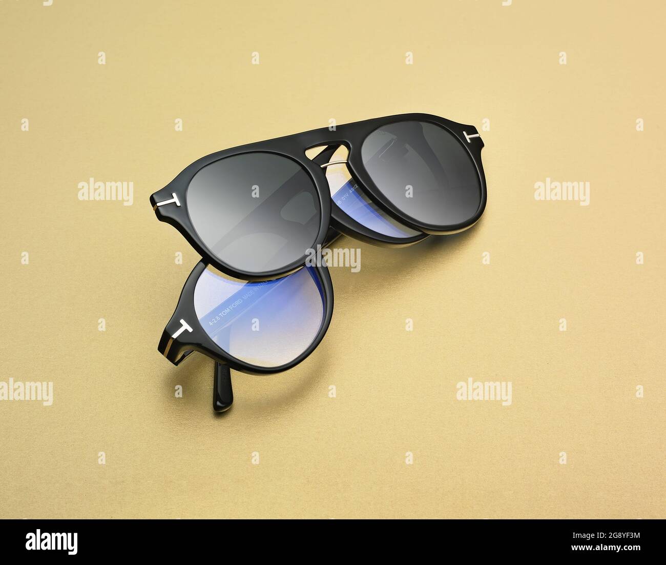 Montature per occhiali Tom Ford, due paia di occhiali, uno sull'altro su  sfondo giallo senape Foto stock - Alamy