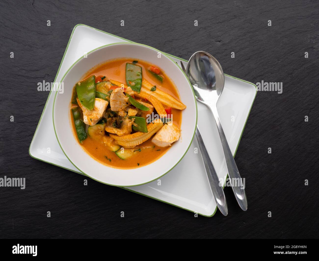 Curry Tailandese Rosso speziato con pollo e verdure in un recipiente, vista dall'alto Foto Stock