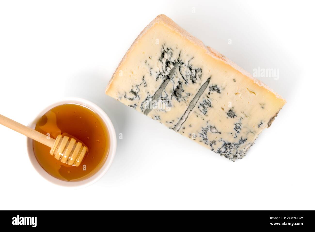 Gorgonzola italiana, fetta di formaggio a muffa blu con ciotola al miele di castagno con cucchiaia in legno su sfondo bianco, vista dall'alto, piatto, spazio copia Foto Stock