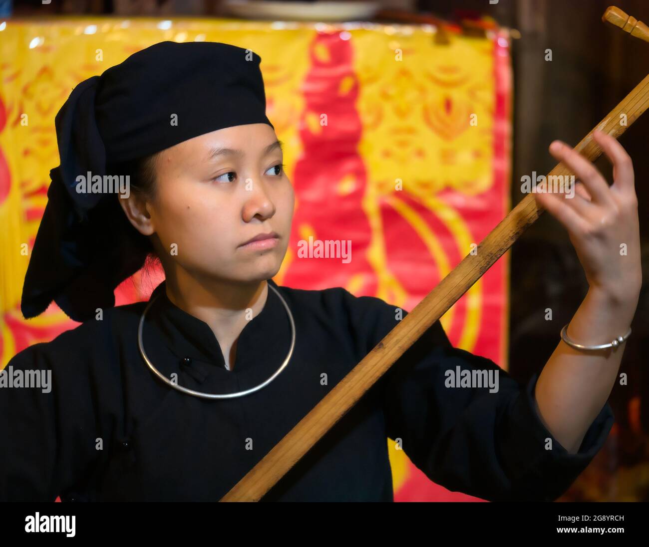 Giovane donna che suona musica tradizionale su liuto al villaggio etnico Thai Hai, provincia di Nguyen tailandese, Vietnam del Nord, Asia Foto Stock