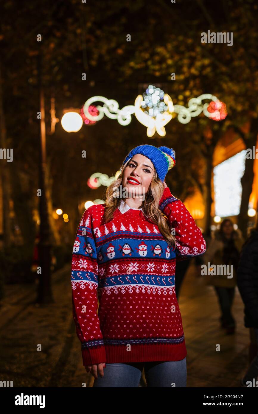 Donna bionda con cappello a maglia e maglione durante Natale Foto Stock