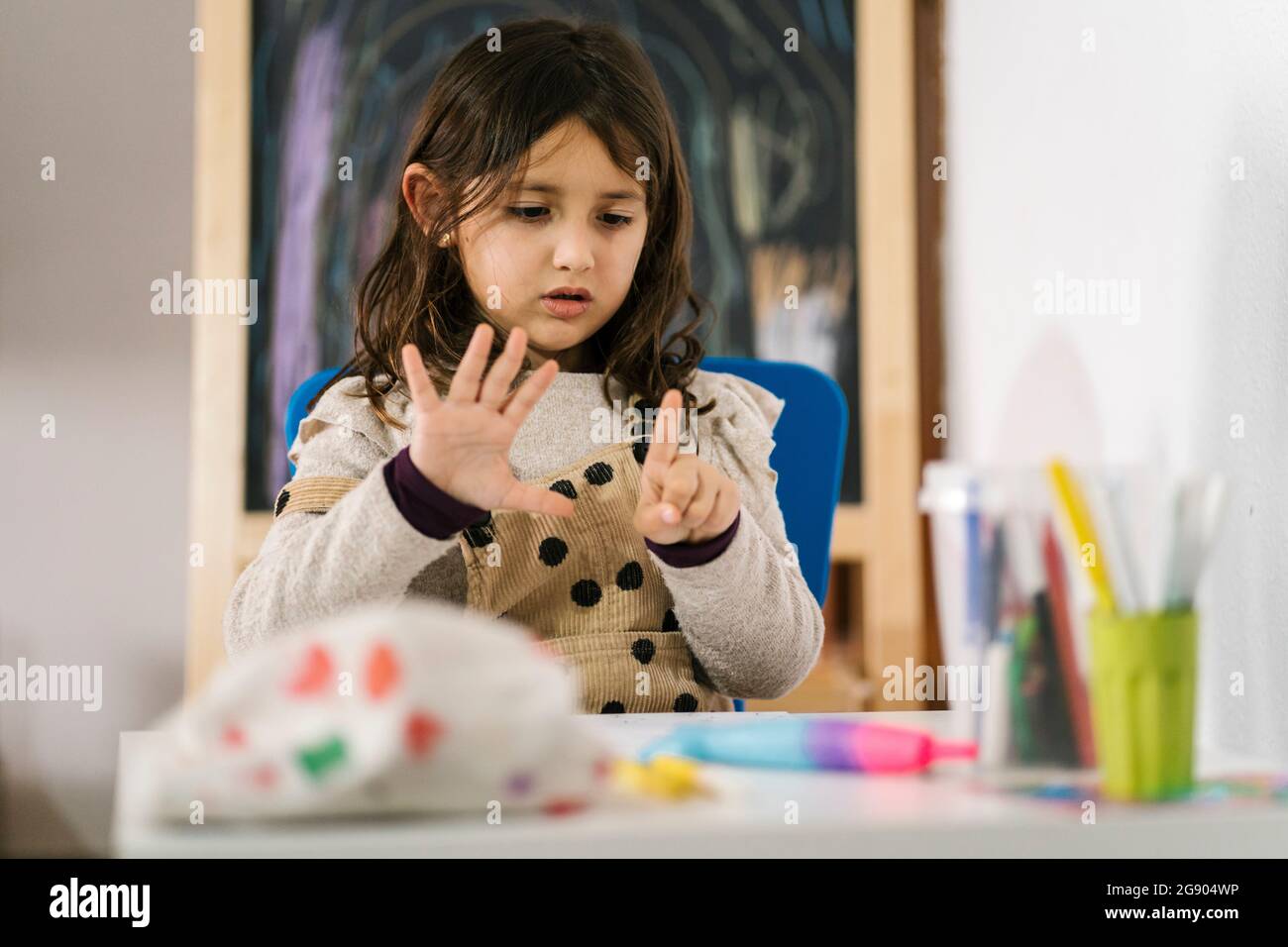 Studentessa contando le dita mentre studia a casa Foto Stock