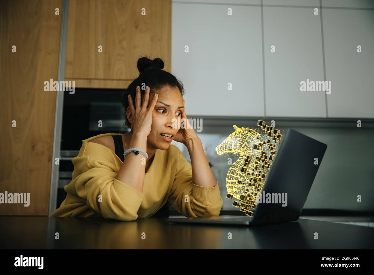 Donna con testa in mano che guarda l'icona del virus trojan sul laptop Foto Stock