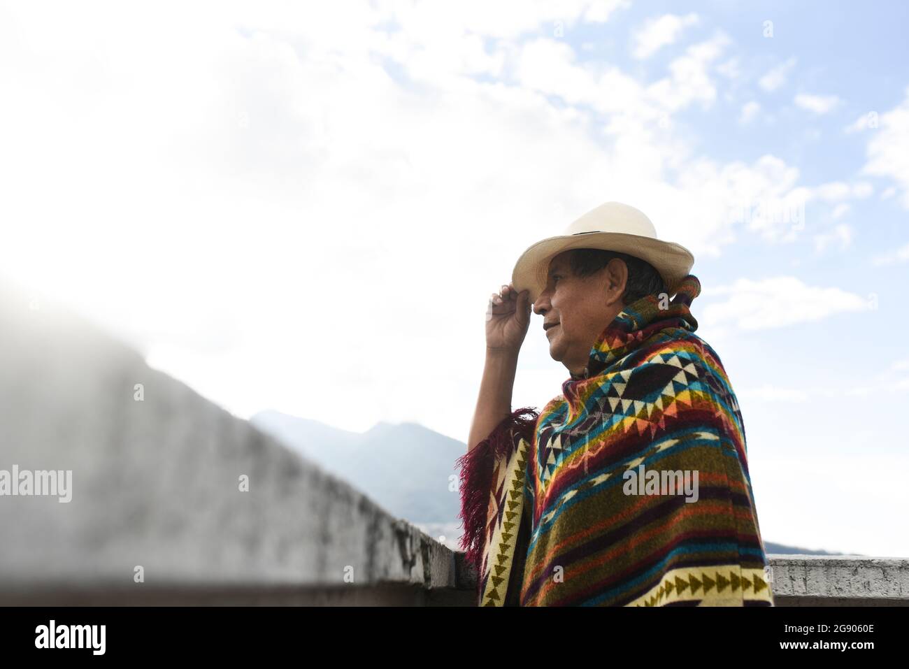 Uomo indigeno che indossa un cappello mentre si alza sul tetto Foto Stock