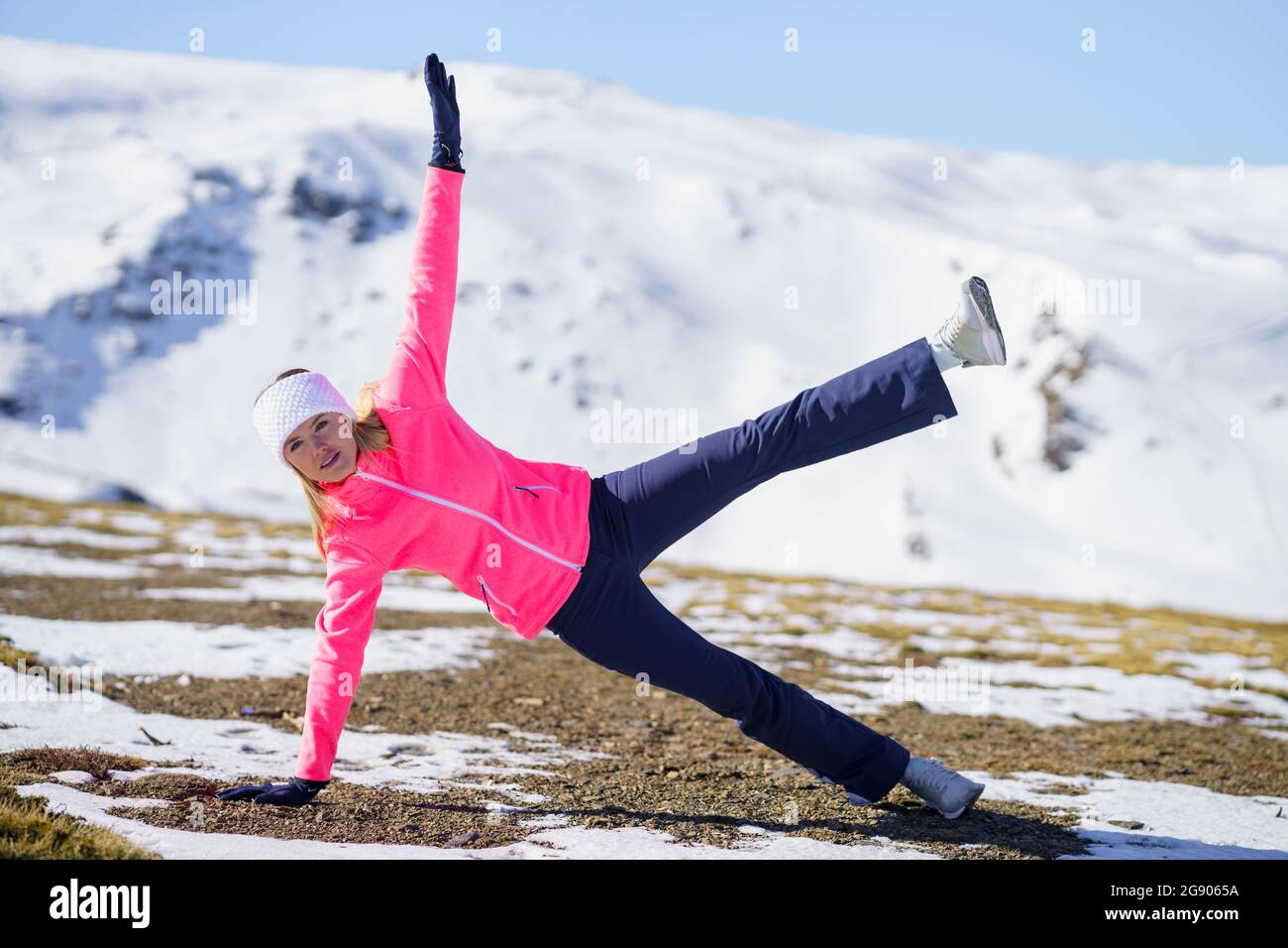 Atleta femminile che si esercita durante l'inverno in giornata di sole Foto Stock