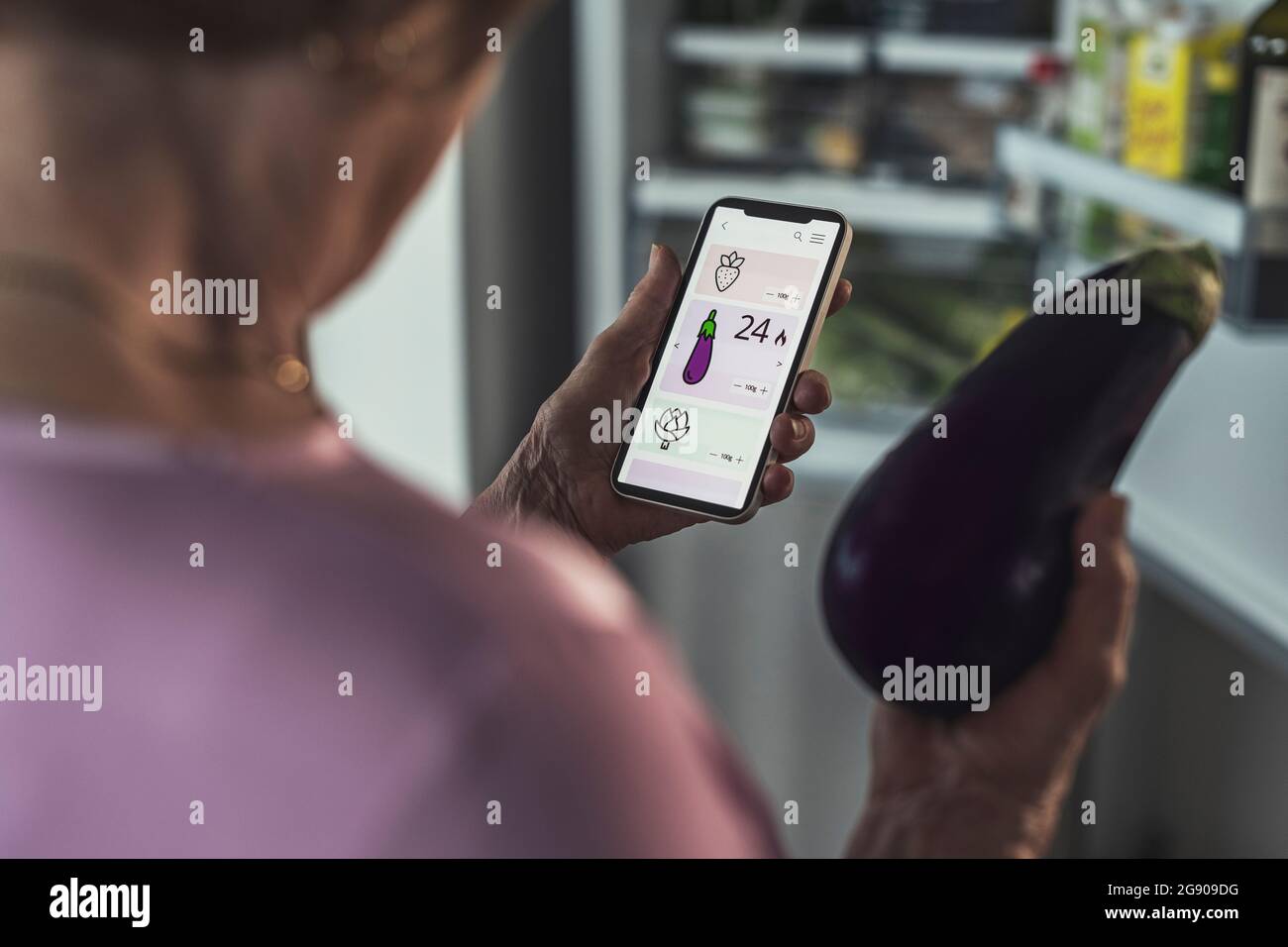 Donna che conta le calorie tramite l'app per smartphone a casa Foto Stock