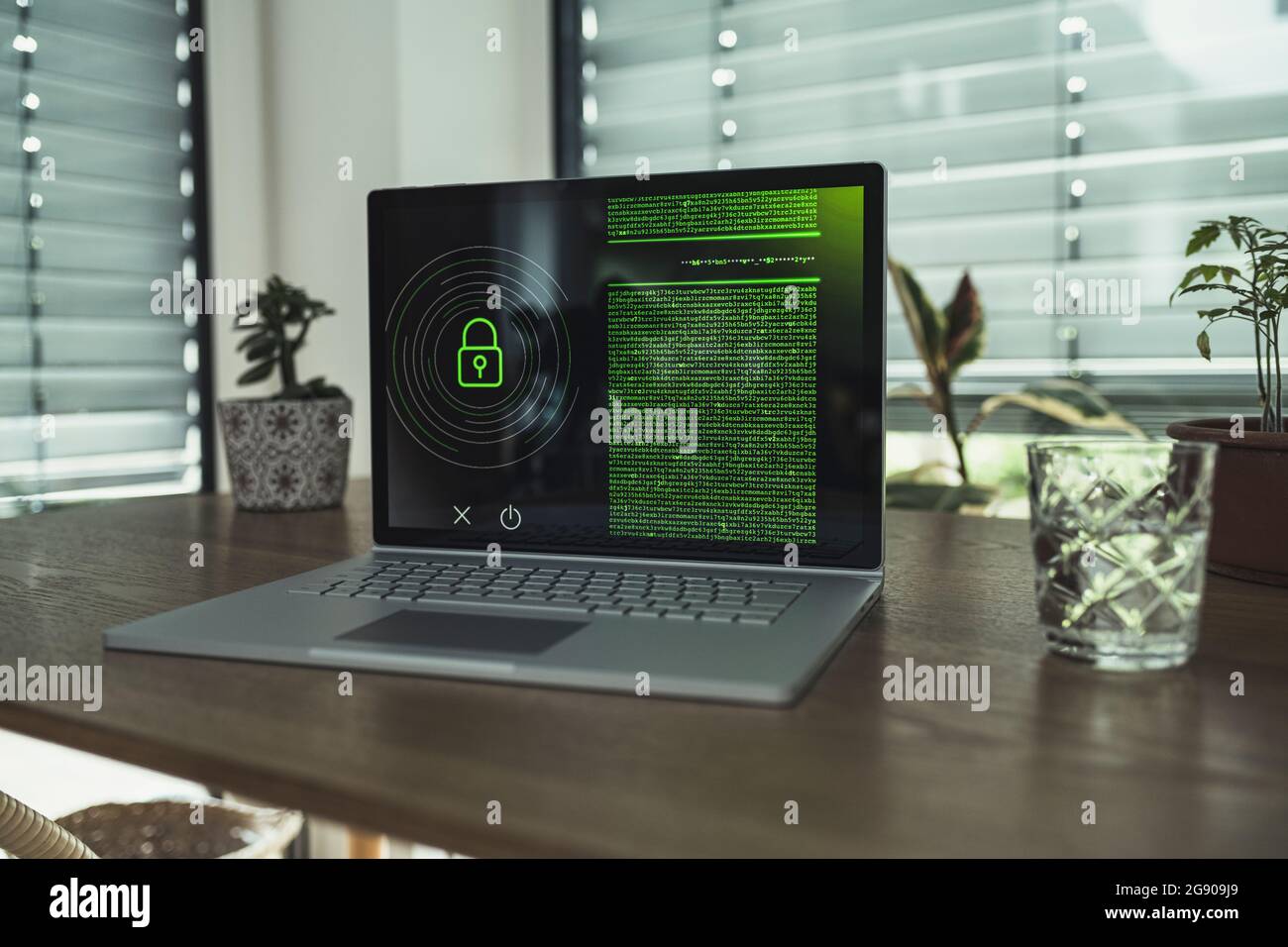 Computer portatile con icona a forma di lucchetto sul tavolo a casa Foto Stock