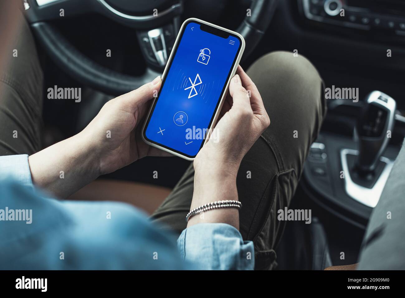Donna che accede al bluetooth sul telefono cellulare in auto Foto stock -  Alamy