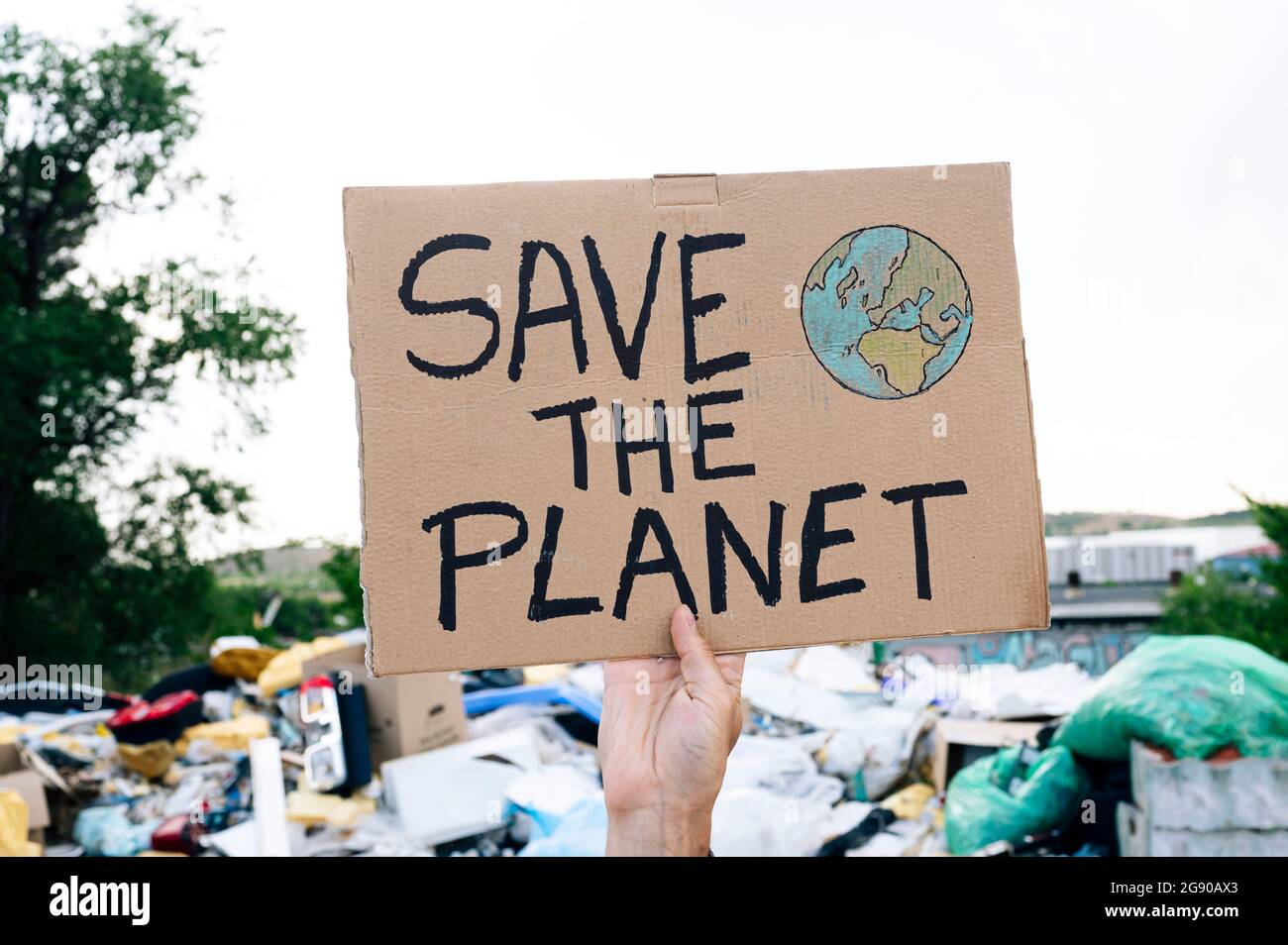 Uomo che tiene salvare il testo del pianeta su cartone Foto Stock