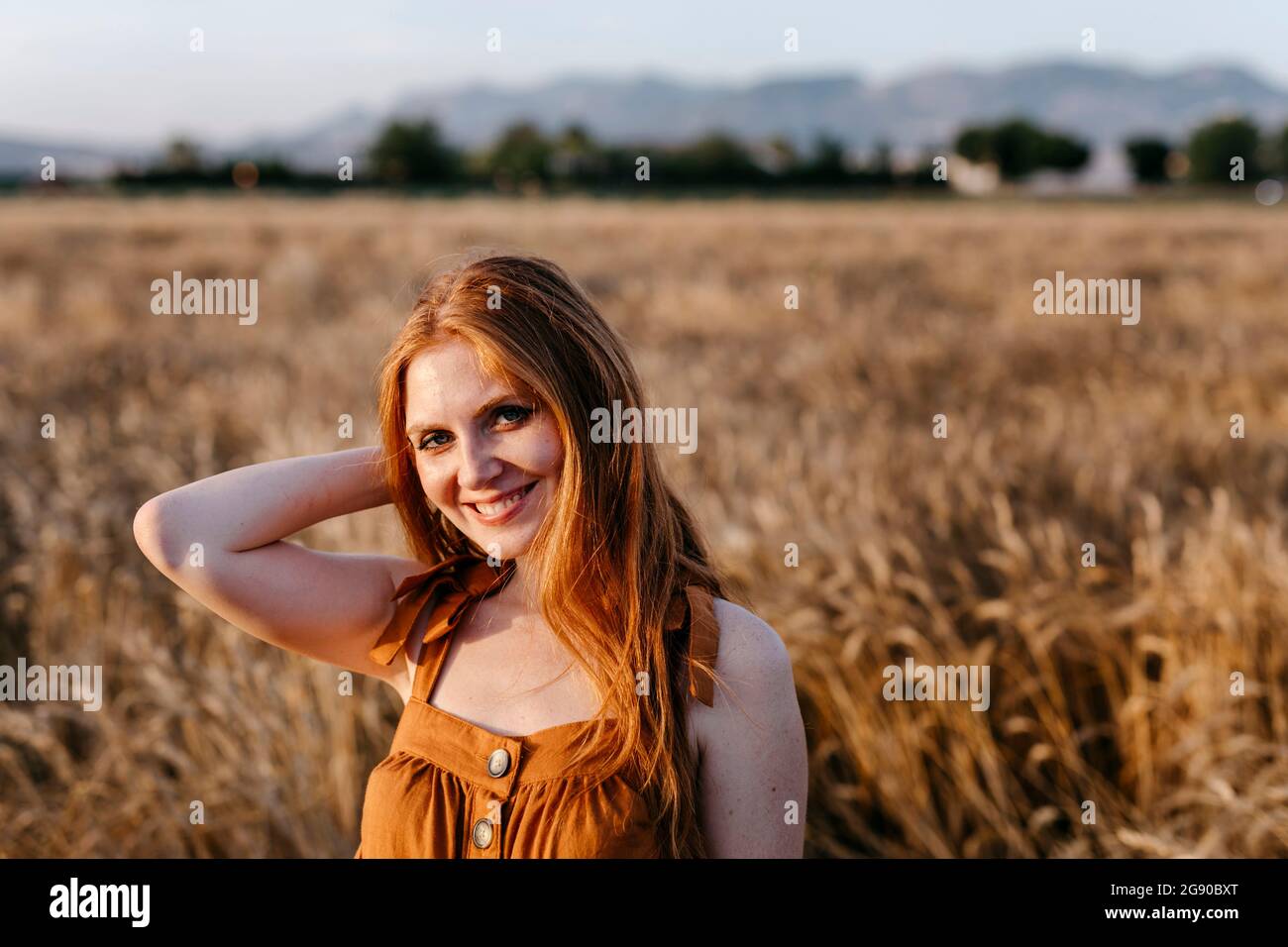 Donna rossa sorridente in campo agricolo Foto Stock