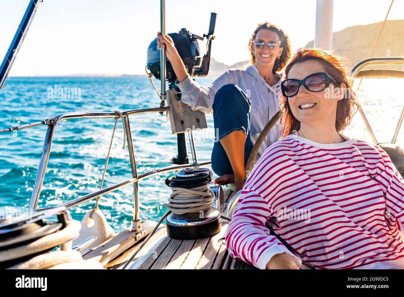 Amici femminili che godono di una giornata di sole sulla nave a vela Foto Stock