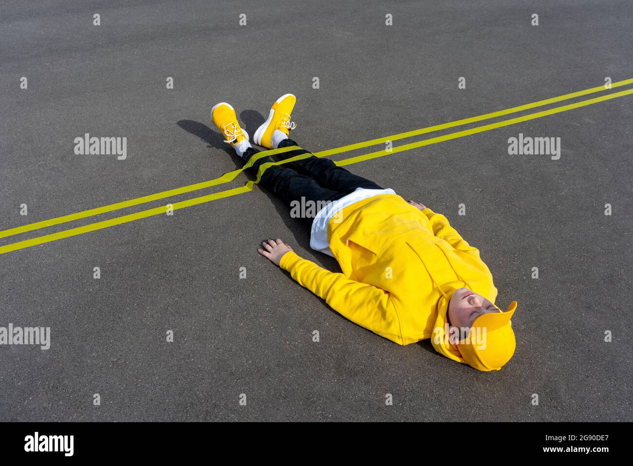 Contrassegno giallo sulla gamba del ragazzo che giace sulla strada Foto Stock