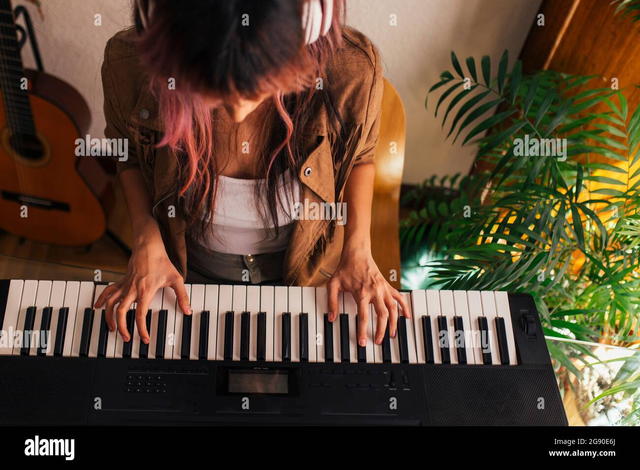 Giovane musicista femminile che suona il pianoforte a casa Foto Stock