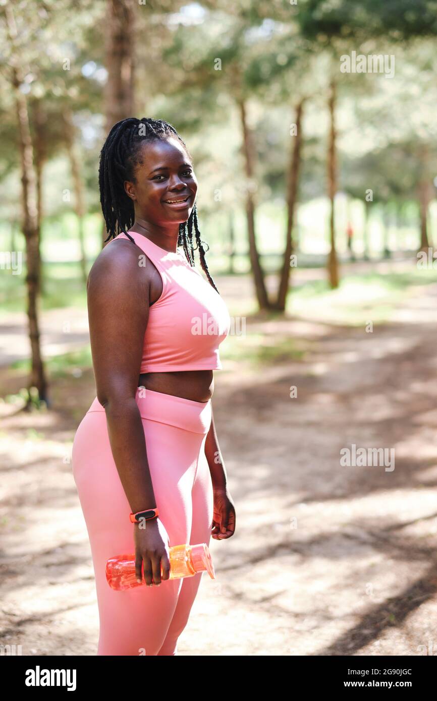 Donna sorridente e di dimensioni più con bottiglia d'acqua Foto Stock