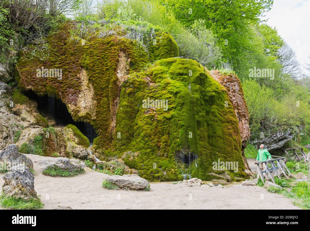 Escursionista senior ammirando la cascata Dreimuhlen che cade giù pendio di Mossy Foto Stock