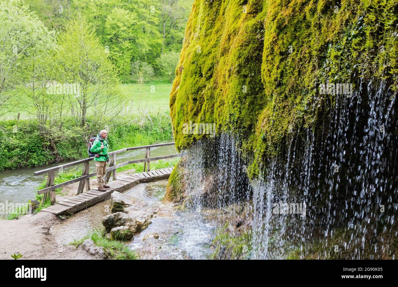 Escursionista senior ammirando la cascata Dreimuhlen che cade giù pendio di Mossy Foto Stock