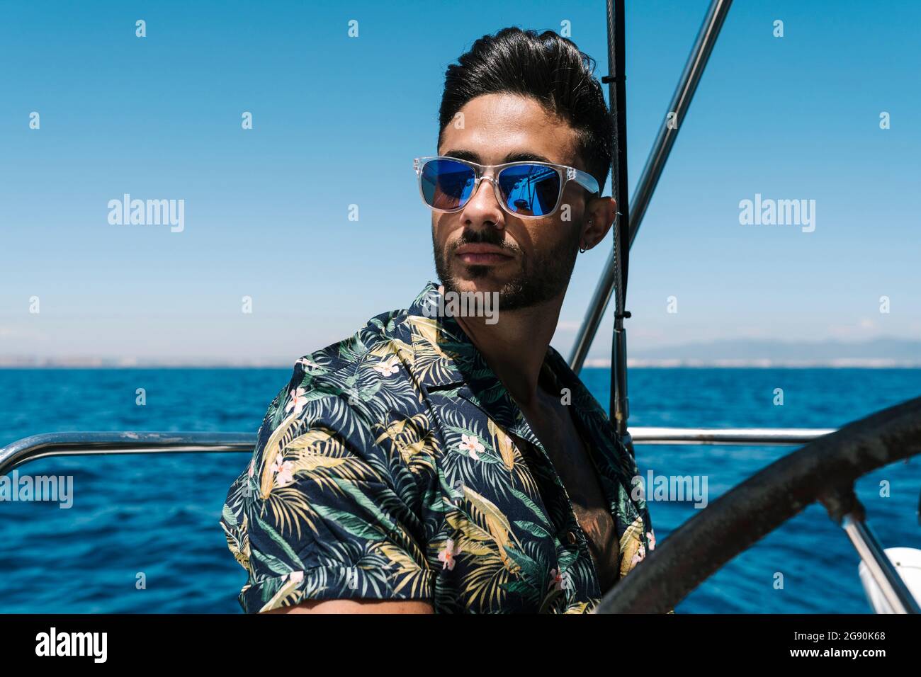 Bel giovane uomo che indossa occhiali da sole viaggiando in yacht Foto Stock