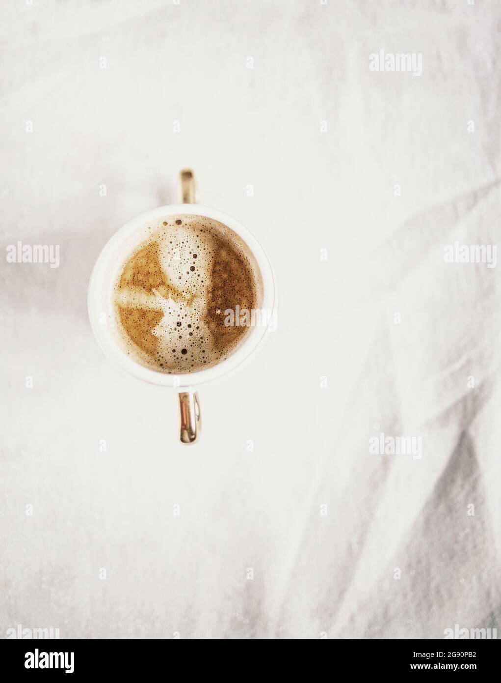 tazza con caffè cappuccino su uno sfondo in tessuto retrò leggermente bianco. Spazio di copia. Disposizione piatta, vista dall'alto. Minimalismo. Foto Stock