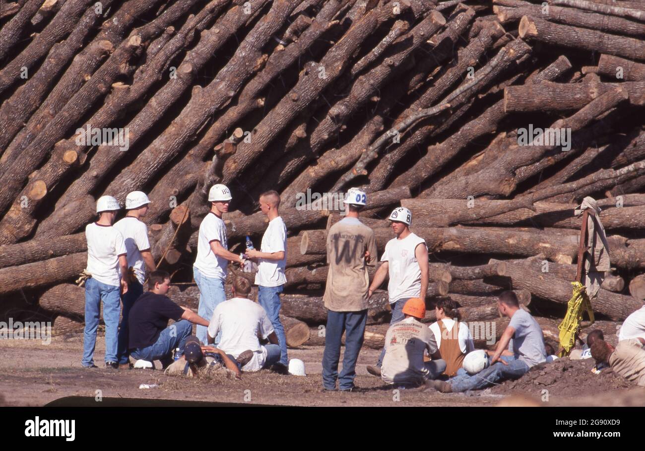 College Station Texas USA, novembre 18 1999: Gli studenti e altri volontari rimuovono i tronchi dalle enormi pile di legname poche ore dopo il crollo di Aggie Bonfire che ha ucciso 12 persone che costruiscono le pile. Bonfire è un rituale condotto dagli studenti nel campus che ha fatto parte delle attività scolastiche che hanno portato alla partita di football annuale Texas-Texas A&M da decenni. ©Bob Daemmrich Foto Stock