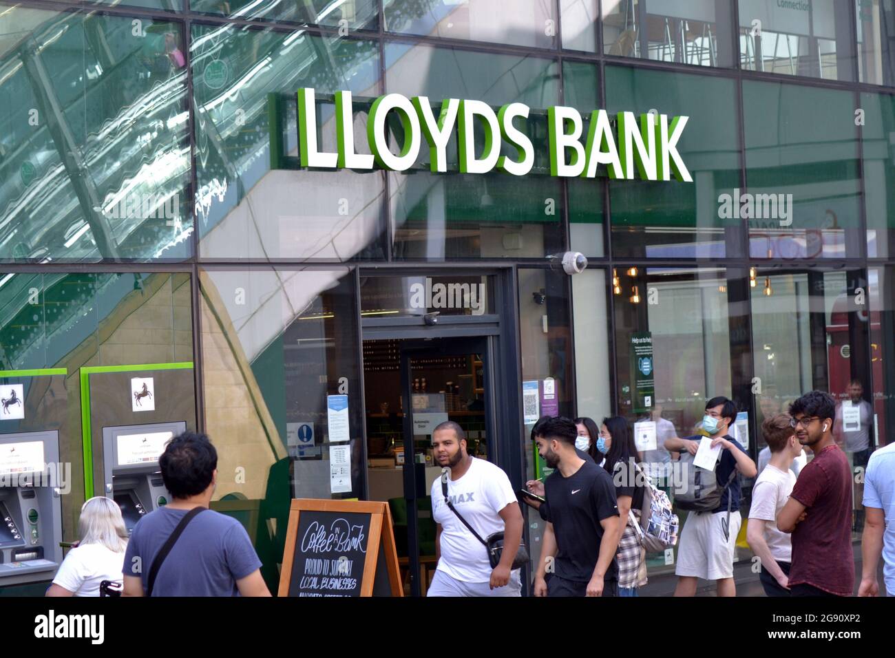 La gente passa davanti a una filiale della banca Lloyds su Market Street, Manchester, Inghilterra, regno unito Foto Stock