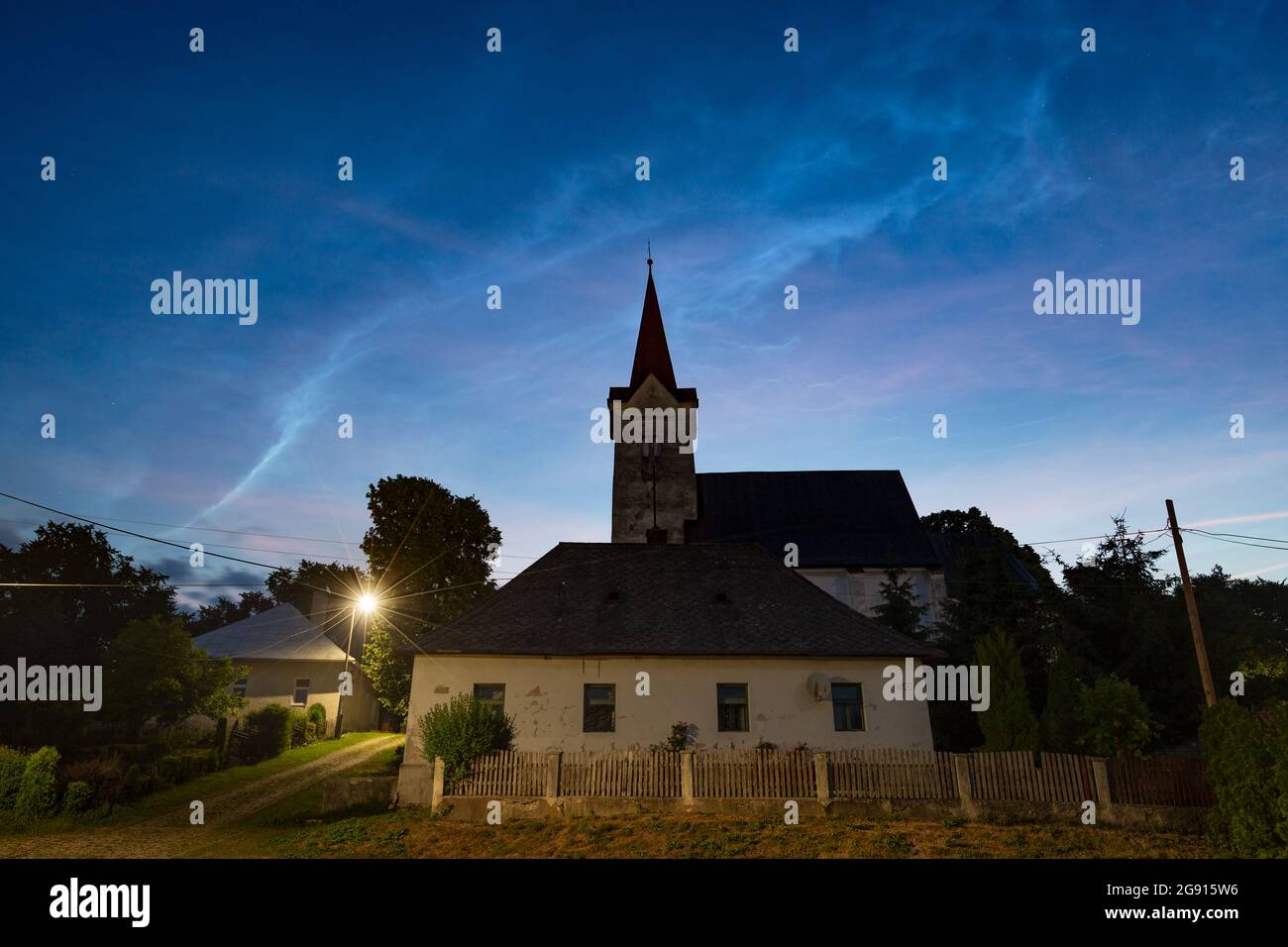 Nubi noctilucenti sopra una chiesa gotica nel villaggio di Turciansky Dur, Slovacchia. Foto Stock