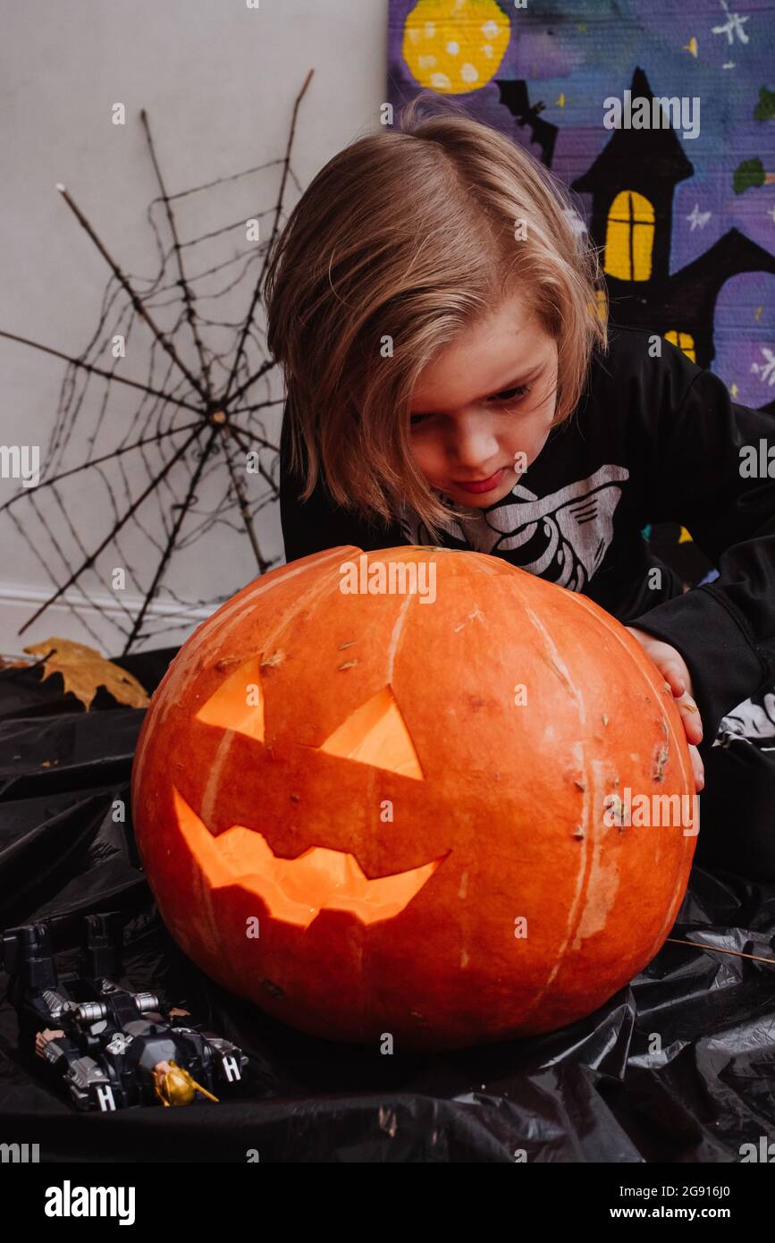 Happy Halloween, bambino che indossa in un costume scheletro facendo sorridere su sfondo grigio Foto Stock