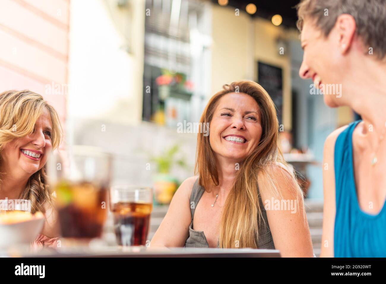 Tre donne adulte di mezza età in un bar che beve e si divertono Foto Stock