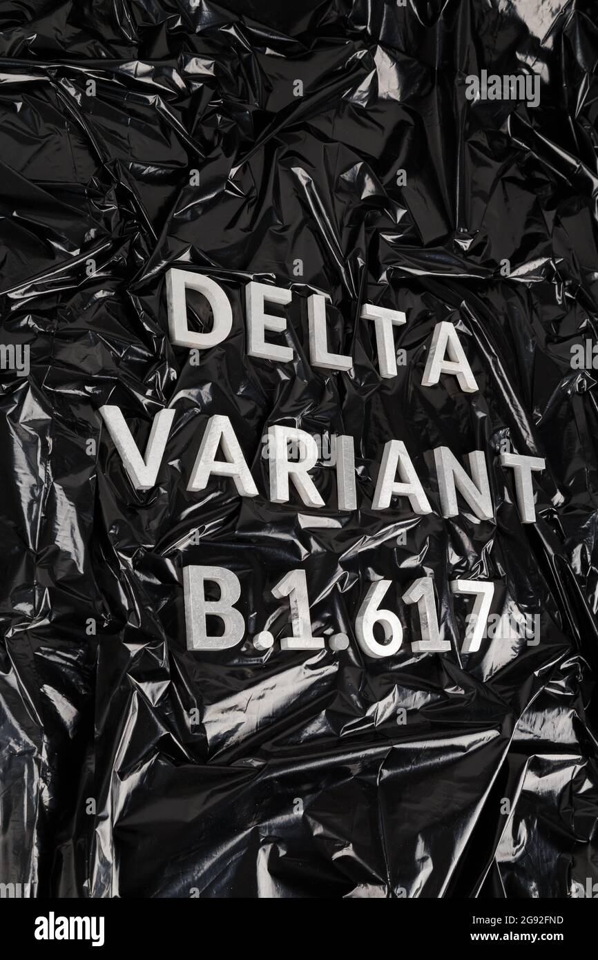 Parole delta variante B.1.617 posate con lettere in metallo argento su fondo nero in plastica sbriciolato in prospettiva diagonale. Foto Stock