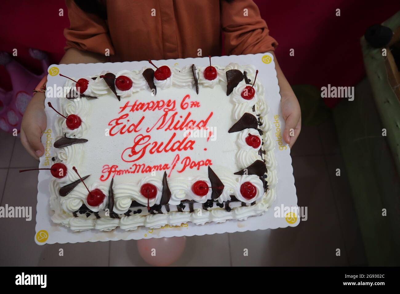 Torta di compleanno che tiene in mano Foto Stock